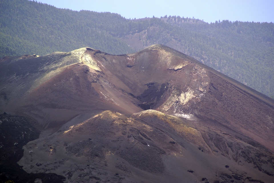 Der Krater des Tajogaite ist mit Lavagestein und hellem Vulkansand gefüllt.